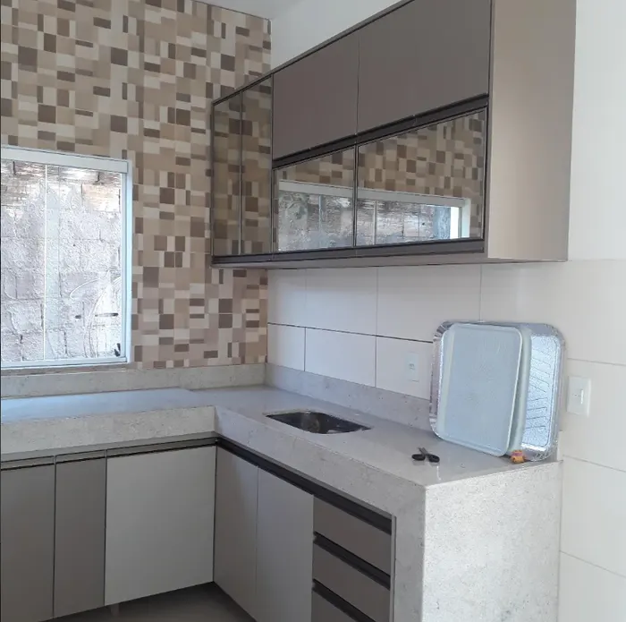 Cozinha planejada em duas cores com armários espelhados e parede em mosaico, projeto Silva Lima Planejados em Santa Luzia