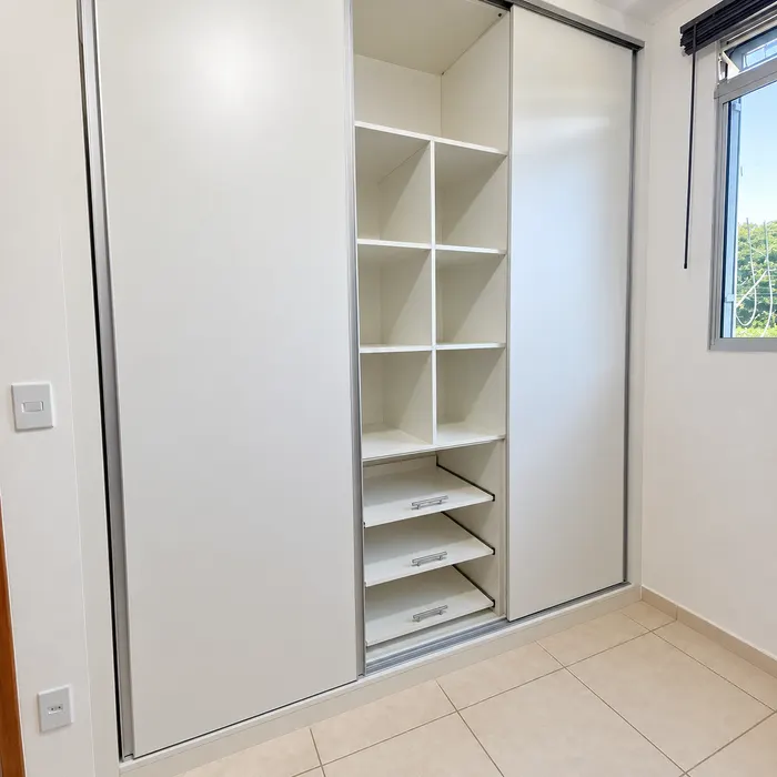 Guarda-roupa planejado branco de correr com prateleiras internas e gavetas, projeto Silva Lima Planejados em Santa Luzia