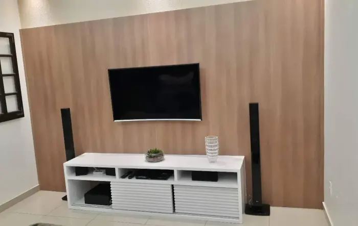 Painel de TV planejado em madeira com rack branco de portas ripadas, projeto Silva Lima Planejados em Santa Luzia