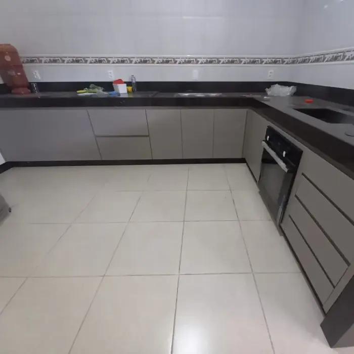 Cozinha planejada cinza com bancada preta e fogão de embutir, projeto Silva Lima Planejados em Santa Luzia
